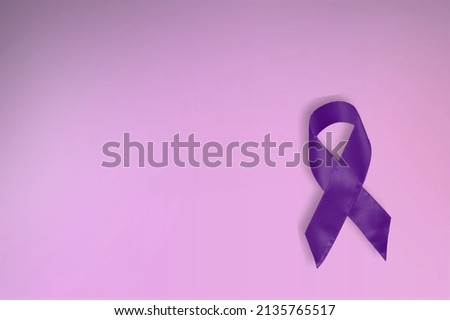 Purple ribbon as symbol of Cancer Awareness Month (World CWorld Cancer Day concept, violet ribbon as symbol of Cancer Awareness Monthancer Day) over purple color background, copy space.