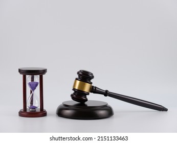 A purple sand hourglass and wooden gavel isolated with white background. - Shutterstock ID 2151133463