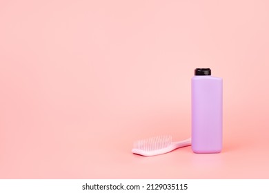 Purple Shampoo Or Conditioner Bottle And Hairbrush Flatlay On Isolated Pastel Pink Background With Copyspace. Concept Selfcare. Mockup