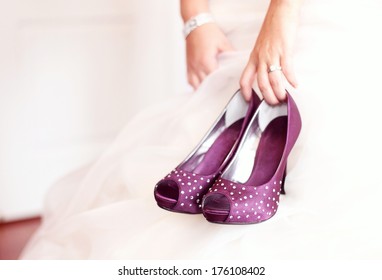 Purple shoes in a bride's hand