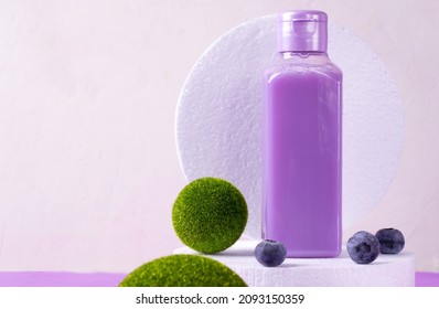 Purple Shower Gel With Blueberry In Bottle On White Podium. Mockup With Unlabeled Body Care Product Or Wash Liquid Detergent With Natural Ingredient
