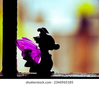 A purple silhouette of a cute baby dragon toy