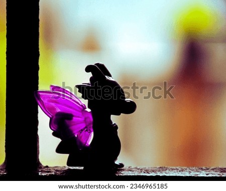 A purple silhouette of a cute baby dragon toy