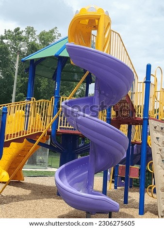 purple spiral long twisted plastic sliding board attached to yellow steps