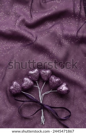 Purple tulle with purple hearts  texture. Lilac fabric background with small hearts. Elegance mesh tulle fabric. Background for holiday.