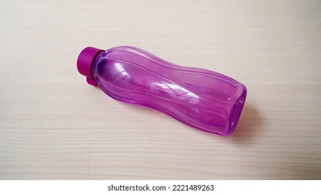 A Purple Water Bottle On A Wooden Table