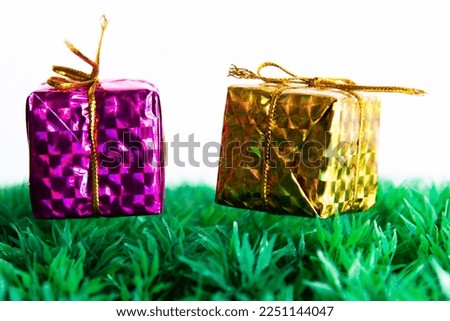 purple and yellow gift boxes placed on green grass