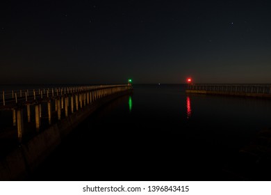 Purposeful Grainy Artistic Photo Of The Two Piers At Night, Red And Green Lights Mark The Ends Whislt Stars Illuminate The Sky, Whitby, North Yorkshire, UK