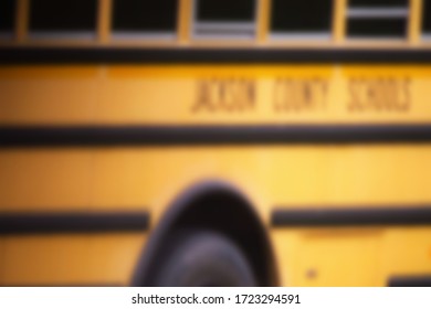 A purposefully blurry, de-focused background of a yellow school bus in an overcast area. 