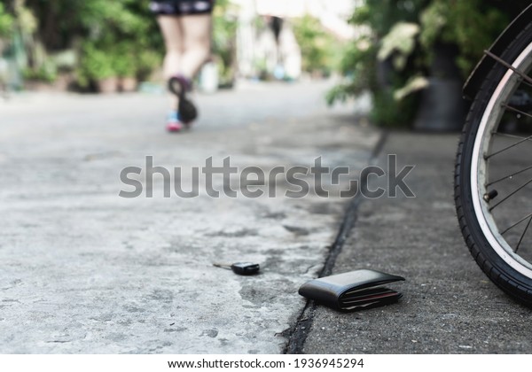The purse and car keys drop to the concrete\
ground.Expected come from her .She is jogging .In the purse have\
credit card and money.