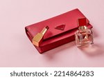 Purse, lipstick ans perfume on pink background