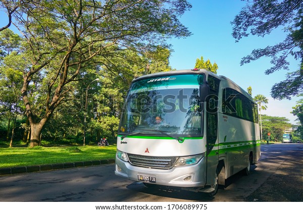 Purwakarta, 16th April 2020. Factory\
employee pickup bus on the highway with trees along the\
road