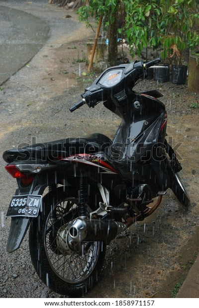 Purworejo/Central Java/Indonesia - Nov 20,2020: A\
motorcycle that is in the middle of heavy rain, a motorcycle that\
is caught in the\
rain.