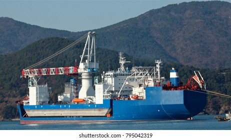 Pusan, South Korea, 13th Of December 2011. Heavy Lift Cargo Ship With Crane Barge On Her Deck  In The Harbour Of Pusan Ready To Leave. 