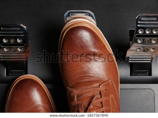 Push break car pedal via brown leather shoes close\
up view