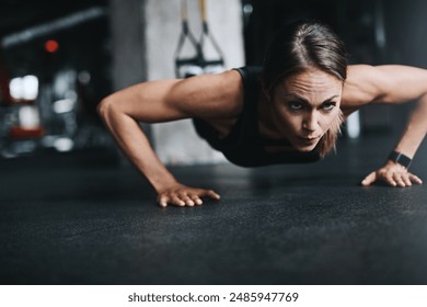 Push ups, girl and fitness in gym on ground for workout, health and wellness with power or resilience. Plank, athlete and training in sports club for exercise, competition and body goals with muscle - Powered by Shutterstock