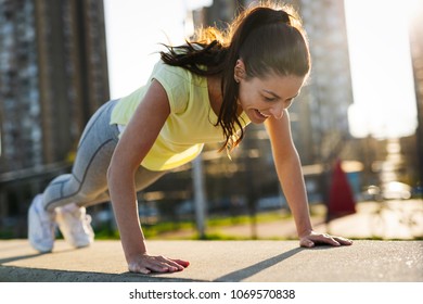 Push ups or press ups exercise by young woman