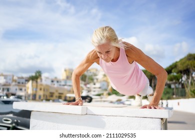 Push Ups Or Press Ups Exercise By Mature Woman. Senior Female Working Strength Training Against Sky With Copyspace.