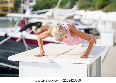 Push Ups Or Press Ups Exercise By Mature Woman. Senior Female Working Strength Training Against Sky With Copyspace.