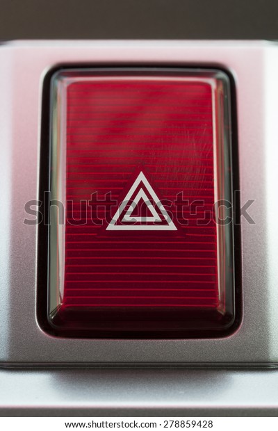 pushed red warning button with triangle\
pictogram, close up view and flasher light.\
