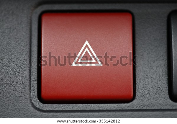 pushed red warning button with triangle
pictogram, close up view and flasher
light.