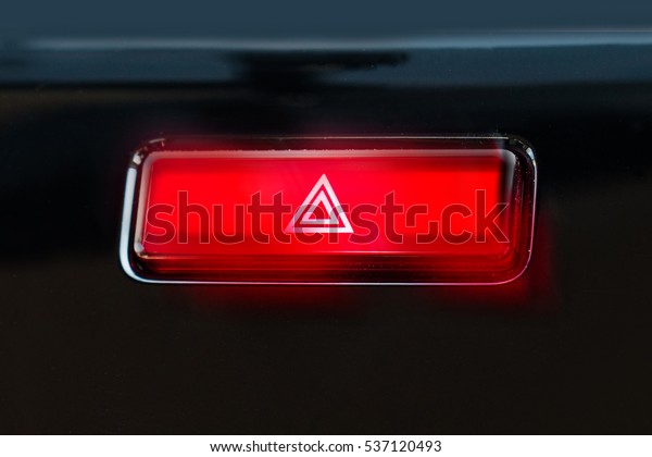 pushed red warning button with triangle pictogram\
and flasher light.