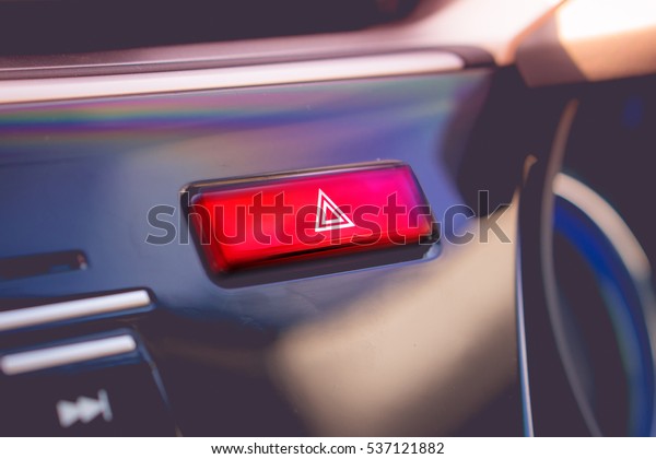 pushed red warning button with triangle pictogram\
and flasher light.
