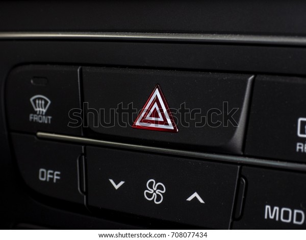 pushed red warning button with triangle\
pictogram, close up view and flasher\
light.