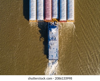 Pusher tug boat headed upstream on the Mississippi River with barges.