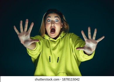 Pushing Away. Portrait Of Young Crazy Scared And Shocked Caucasian Woman Isolated On Dark Background. Copyspace For Ad. Bright Facial Expression, Human Emotions Concept. Looking Horror On TV, Cinema.