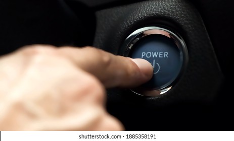 pushing blue  power ignition button to start keyless ignition hybrid car engine