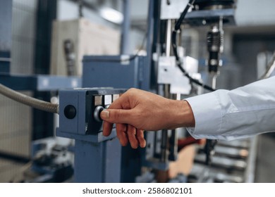 Pushing the button of machine. Close up view of man that is working in the modern factory.