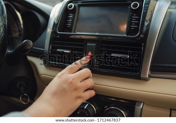 pushing the car emergency button on car\'s dashboard,\
inside car.