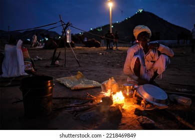 Pushkar, India - November 6, 2019: Indian Rural Village Men And Camels Lit By Camp Fire In Night At Pushkar Camel Fair Pushkar Mela - Annual Famous Camel And Livestock Fair And Tourist Attraction