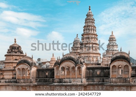 Pushkar, India - Rooftop view of city skyline with temples and royal palaces under bright blue sky and clouds in Pushkar, Rajasthan, India.