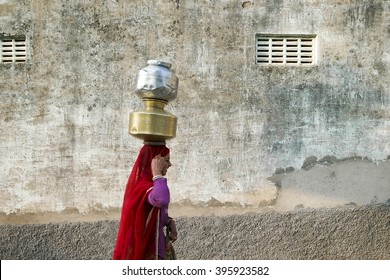 Pushkar, India-November 23, 2015:Unidentified Local Indian Women Carrying A Water Bucket In The Street Of Pushkar. Many Parts Of Urban India Are Experiencing Acute Water Shortage.