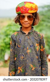 Pushkar, Rajasthan India August 19 2021: Portrait of a slum girl wearing rajasthani turban and sunglasses