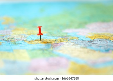 pushpin on world map with blurry background
