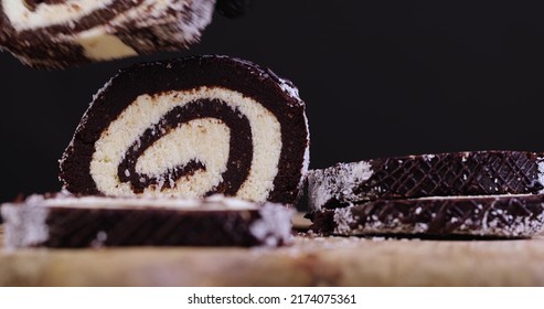 put a chocolate roll with a creamy curd layer in coconut chips, a roll of cakes and cottage cheese cut into pieces - Shutterstock ID 2174075361