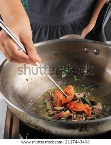 Put Kimchi with Chopstick to the Pan, Cooking Process Making Korean Food Kimchi Bokkeumbap, Selective Focus 