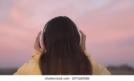 Put On Headphones On Your Head, A Beautiful Pink Sunset In Sky, Listen To Music Tracks In Speakers With Your Ears, Get Musical Pleasure And Relax, Record Audio At Sunset, Diversify Your Leisure Time