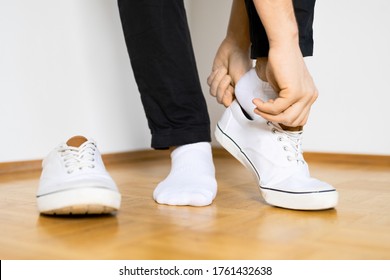 put on white sneaker shoes on wooden floor and white background