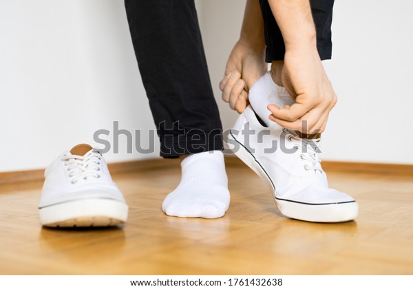 put on white sneaker shoes on wooden floor and\
white background
