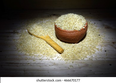 Put the rice in a clay cup Available on the wooden floor Grain and rice sprinkled on a wooden floor. Get plenty of shooting State Lighting. - Shutterstock ID 466670177