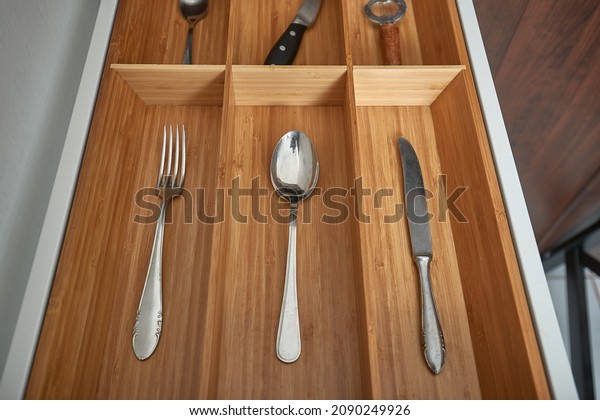 Puting one piece of
types of cutlery in the drawer of the kitchen cabined as a
minimalist organizing
system