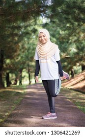 Putrajaya, Malaysia - February 2019 : Unidentified muslim woman wearing sport attire with hijab doing stretching exercise outdoor. Healthy lifestyle concept. - Shutterstock ID 1306421269