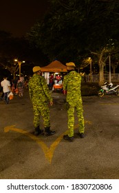 Putrajaya, Malaysia - October 09, 2020: Street food night market at  Putrajaya, near Kuala Lumpur. Security officers monitor compliance with the Corona distance rules. Face masks are compulsory 