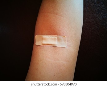 Putting Adhesive Bandage On Arm