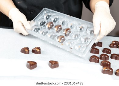Putting chocolate in mold, make praline - Handmade chocolate mold - Image - Powered by Shutterstock