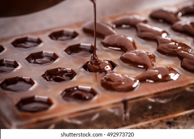 Putting chocolate in mold, make praline - Powered by Shutterstock